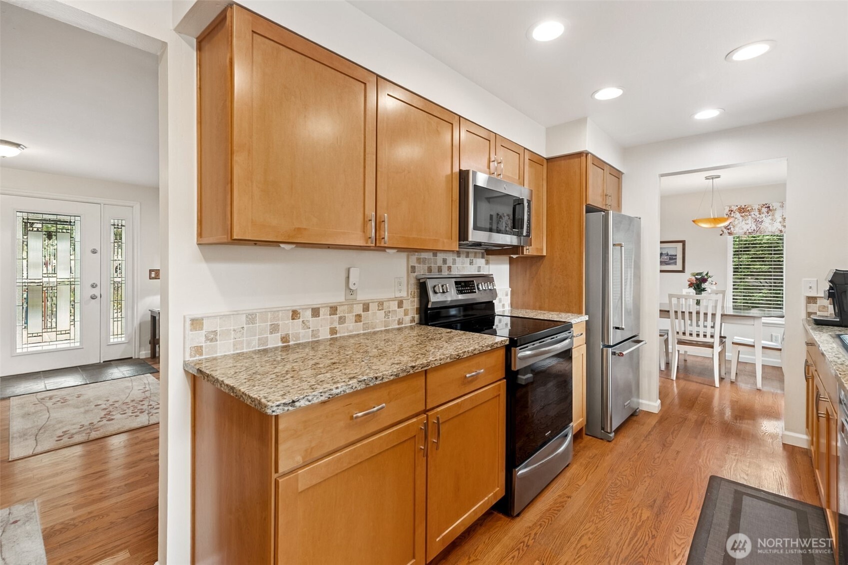 20623 98th Place South Kent, WA 98031 - Photo 11 of 37 a kitchen with stainless steel appliances granite countertop a stove top oven a sink dishwasher a refrigerator and white cabinets with wooden floor
