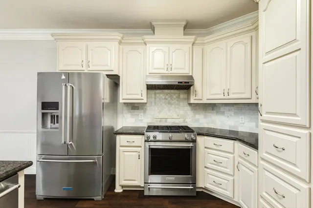 a kitchen with stainless steel appliances white cabinets and a refrigerator