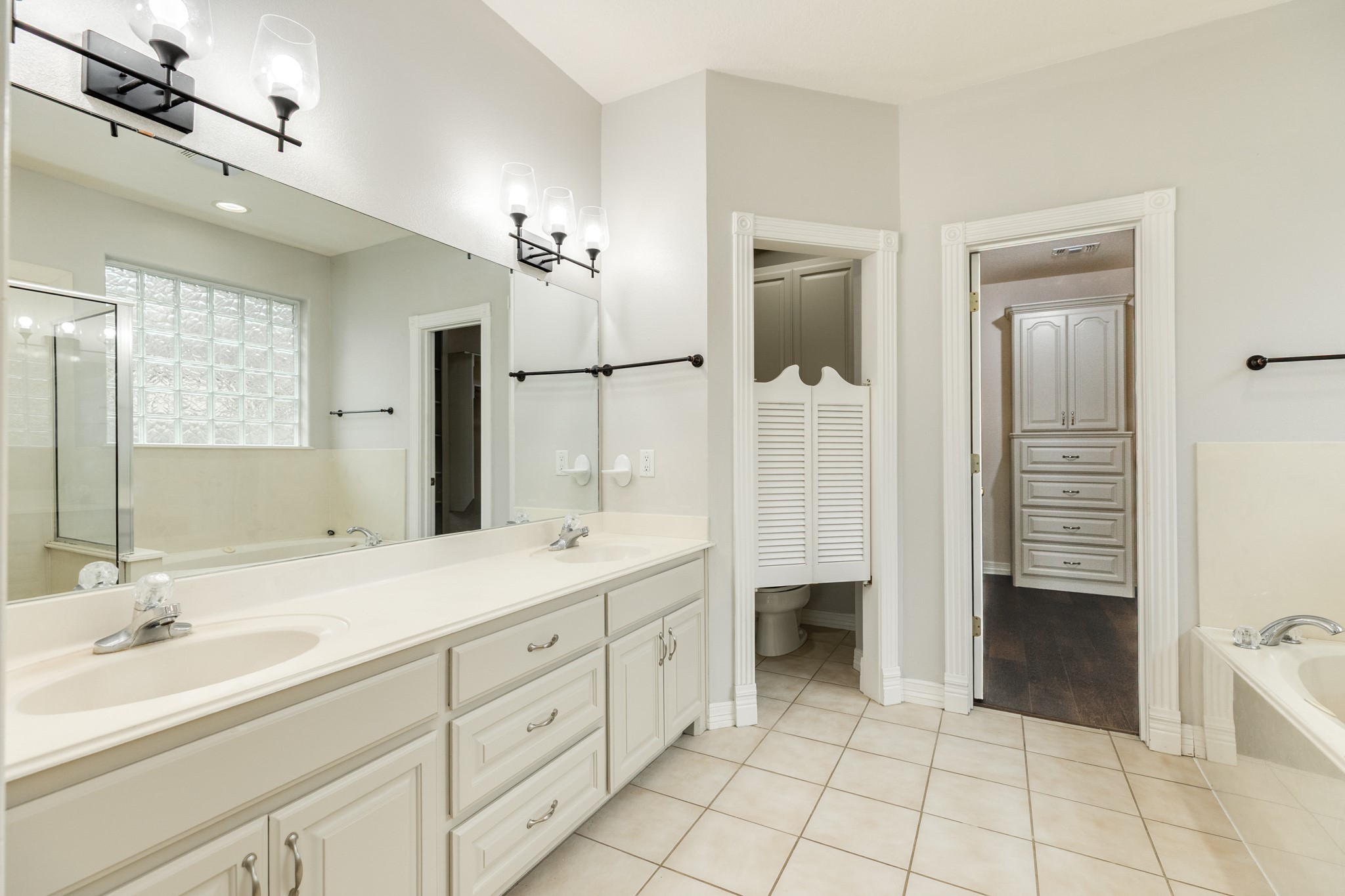 900 Enchanted Oaks Drive Angleton, TX 77515 - Photo 20 of 36 a spacious bathroom with a double vanity sink a mirror and a bathtub