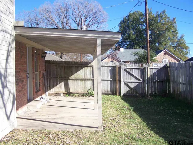 a view of house with backyard and tree