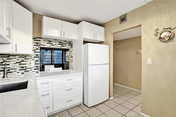 a kitchen with white cabinets and white appliances
