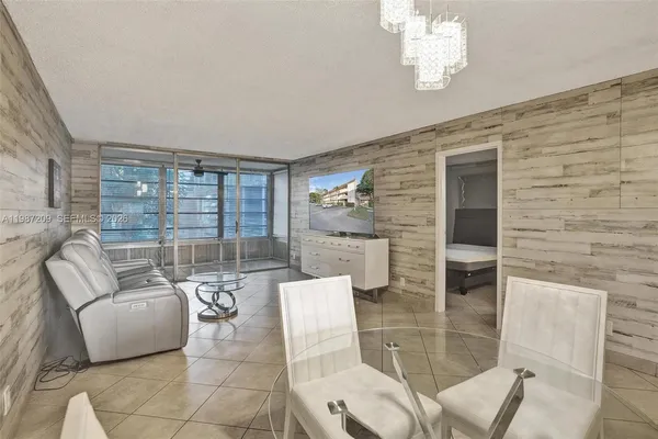 a living room with furniture a large window and chandelier