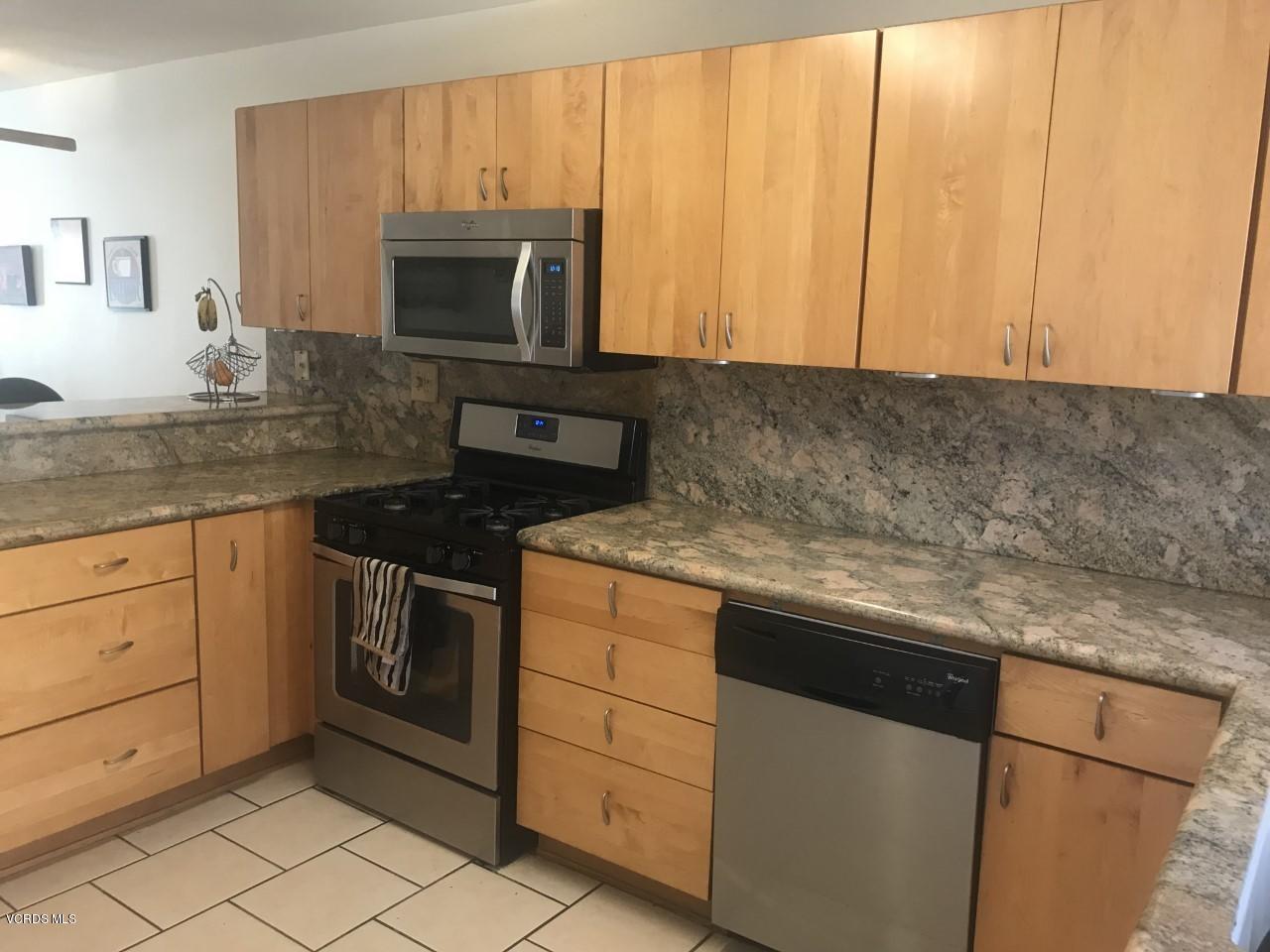 500 Percy Street, Unit 54 Oxnard, CA 93033 - Photo 4 of 9 a kitchen with granite countertop white cabinets and stainless steel appliances
