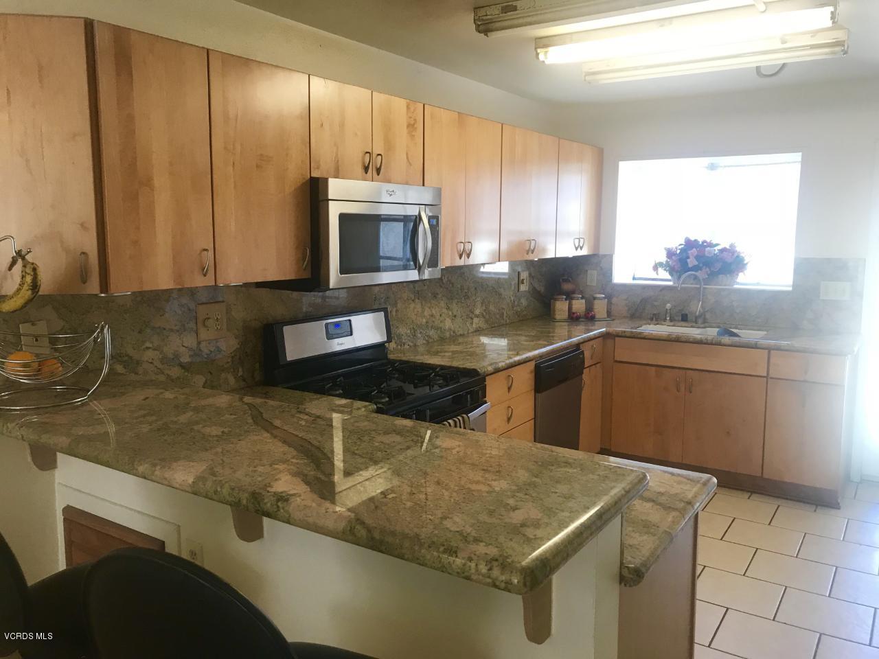 500 Percy Street, Unit 54 Oxnard, CA 93033 - Photo 5 of 9 a kitchen with stainless steel appliances granite countertop a sink stove and microwave