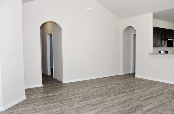 an empty room with wooden floor and a window