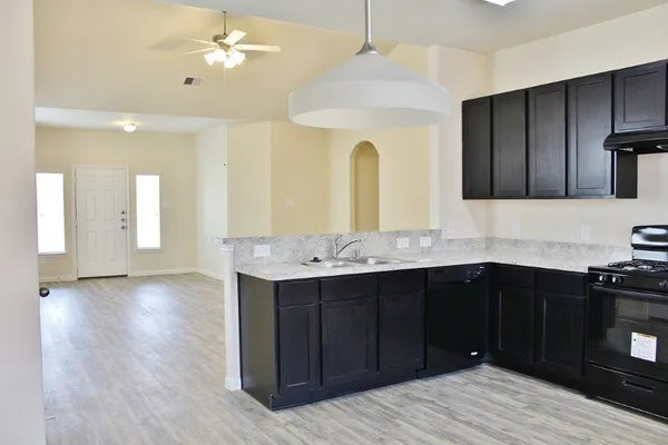 a kitchen with a sink chandelier and stove