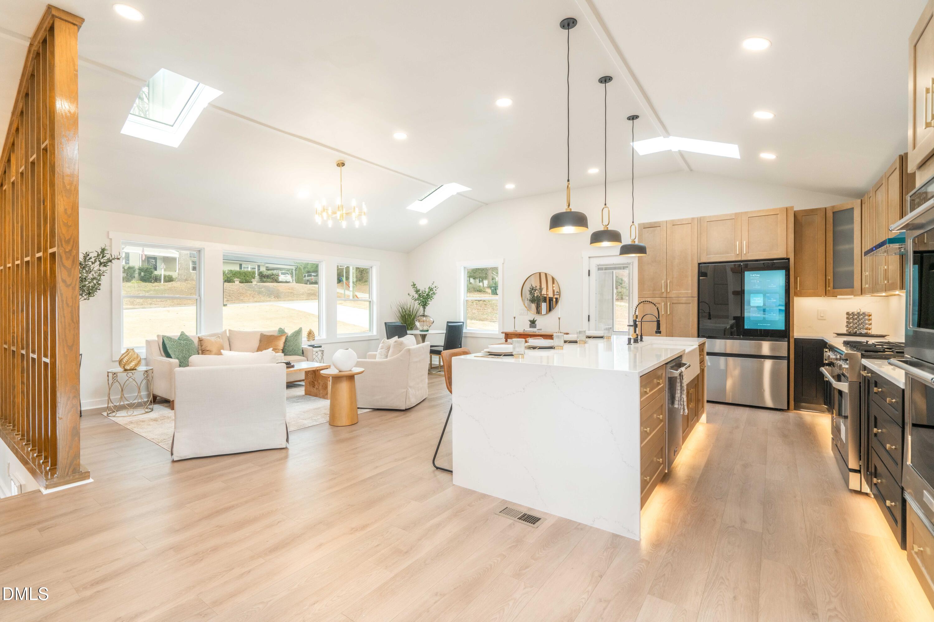 721 Currituck Drive Raleigh, NC 27609 - Photo 19 of 81 a living room with couches a flat tv screen and kitchen view with wooden floor