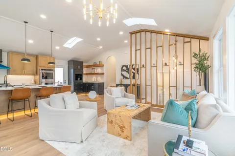 a bathroom with a double vanity sink a large mirror and a bathtub