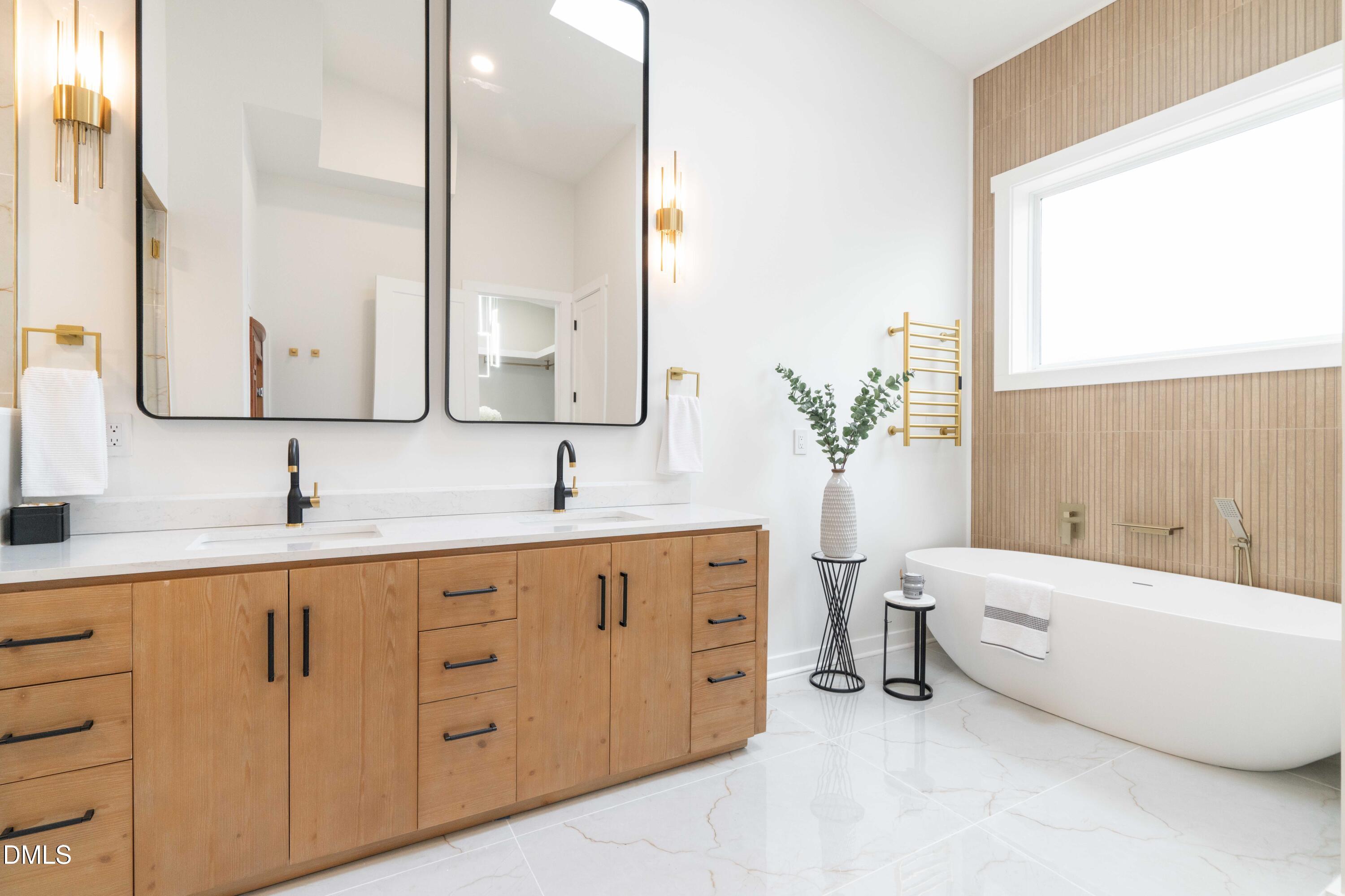721 Currituck Drive Raleigh, NC 27609 - Photo 36 of 81 a bathroom with a double vanity sink a large mirror and a bathtub