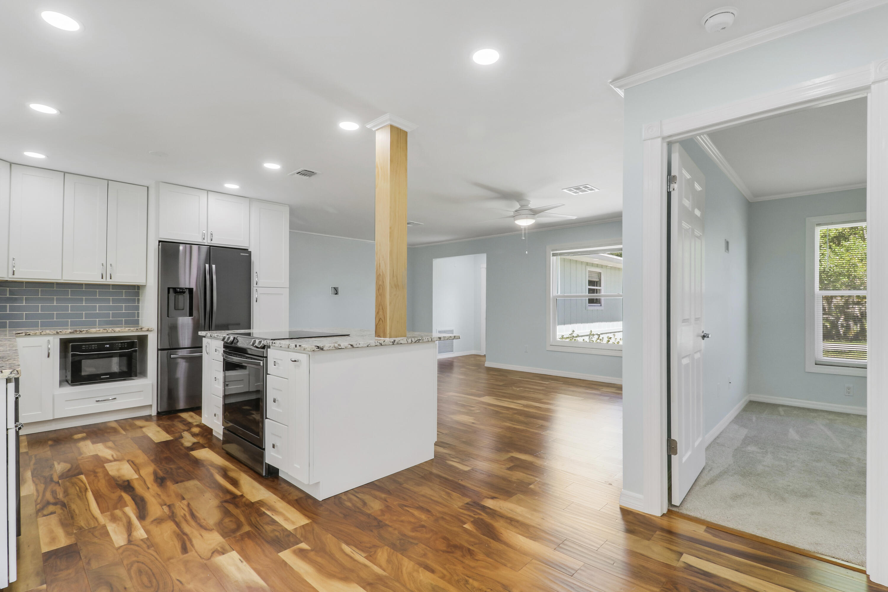 5909 Seagrape Drive Fort Pierce, FL 34982 - Photo 11 of 27 a living room with stainless steel appliances kitchen island granite countertop a refrigerator and a stove top oven