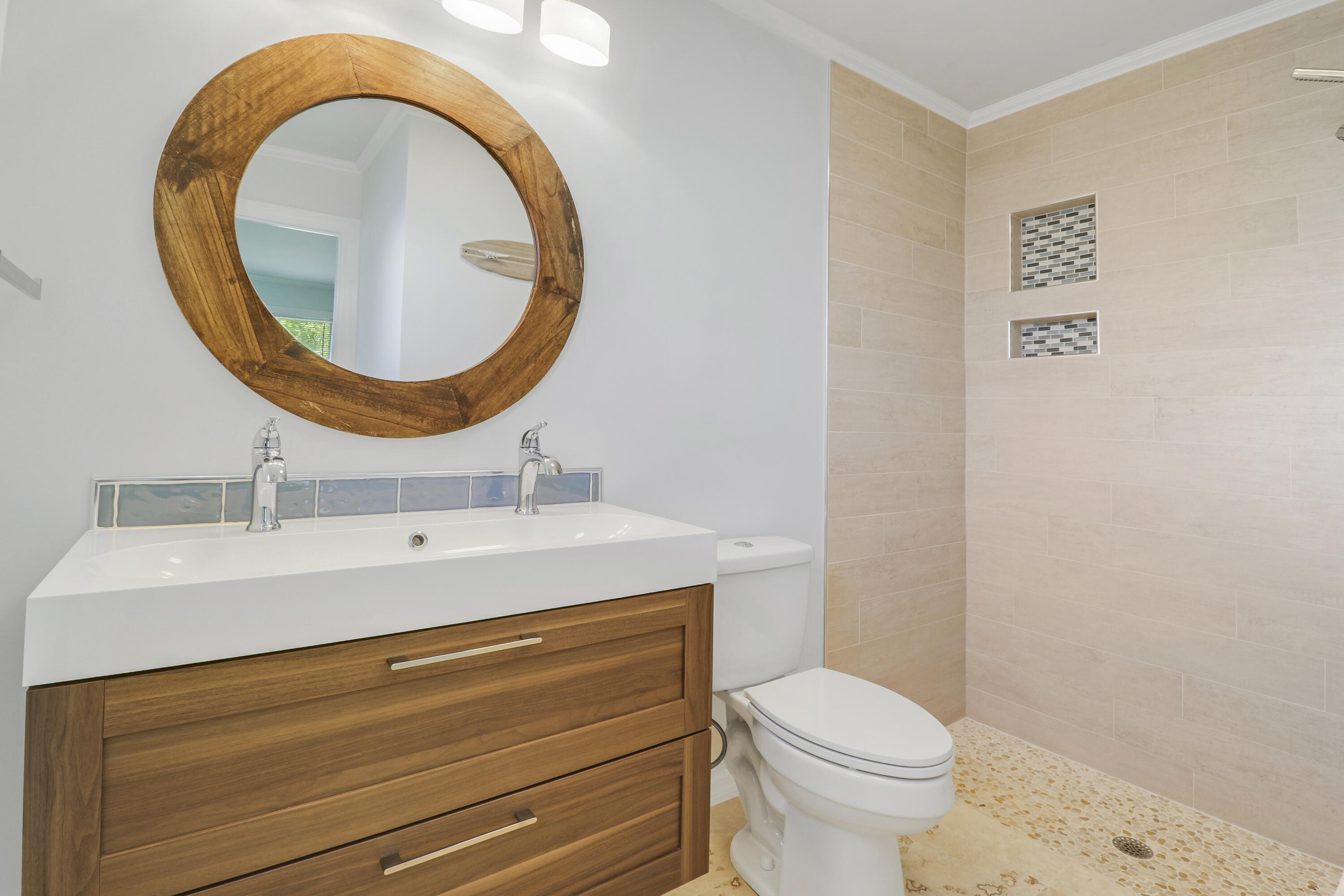 5909 Seagrape Drive Fort Pierce, FL 34982 - Photo 16 of 27 a bathroom with a sink a mirror and a toilet