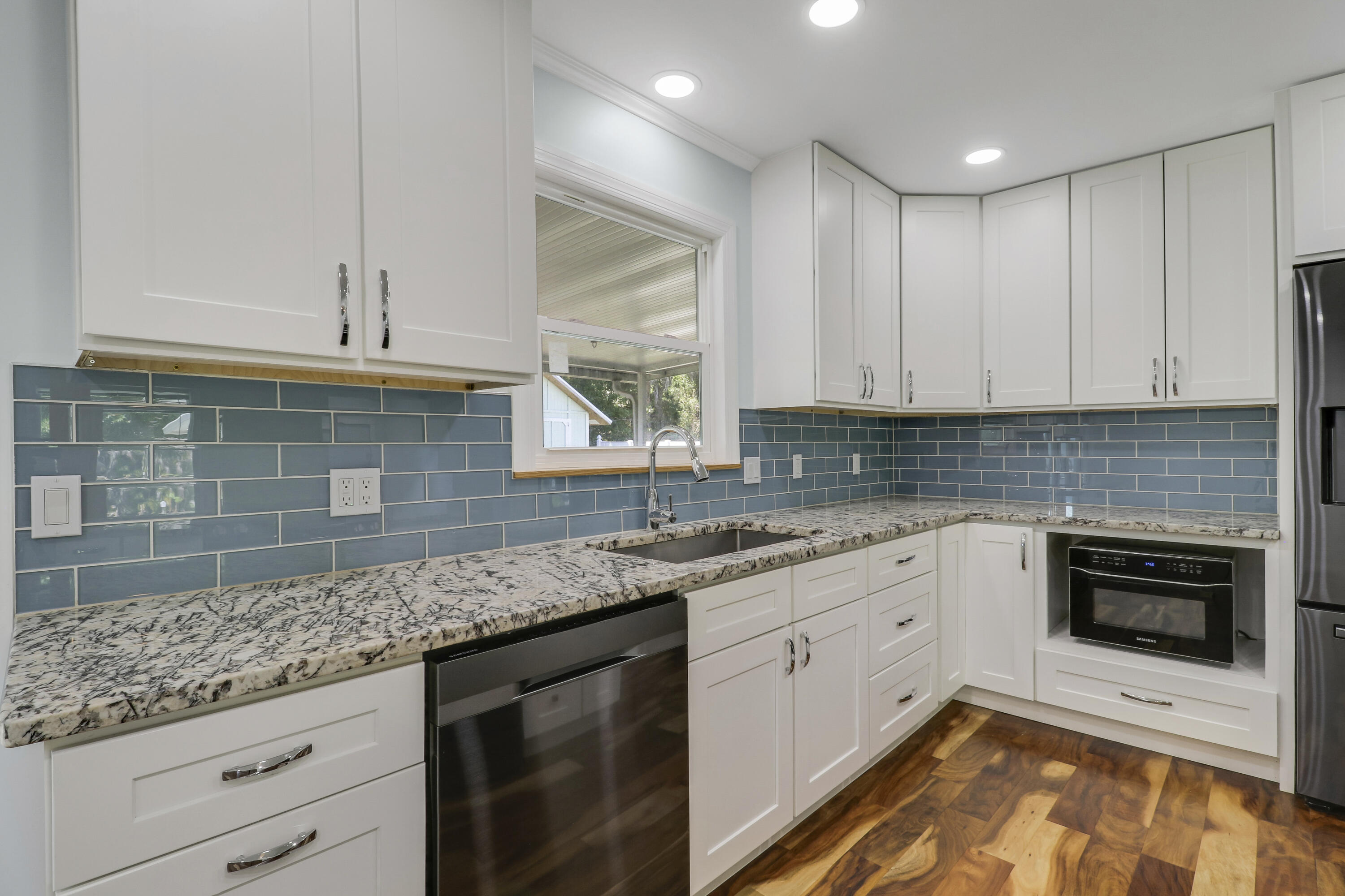 5909 Seagrape Drive Fort Pierce, FL 34982 - Photo 9 of 27 a kitchen with granite countertop kitchen island white cabinets stainless steel appliances and a counter space