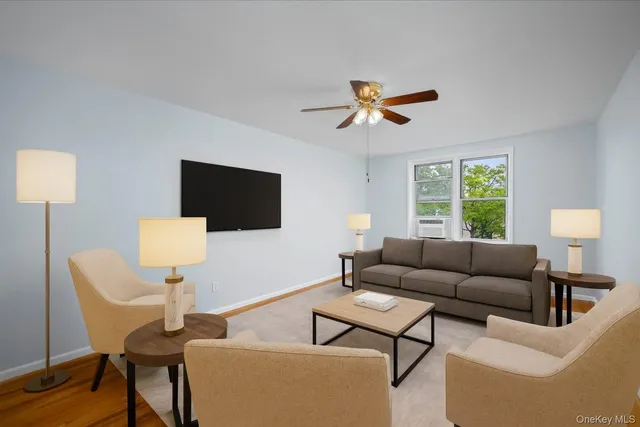 a living room with furniture a flat screen tv and a window