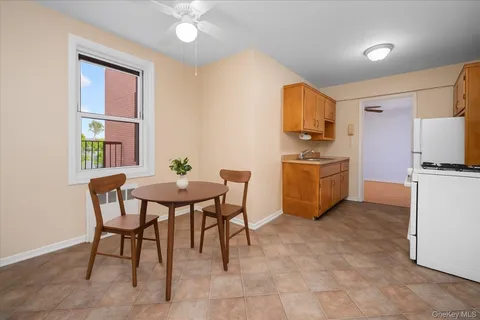 a kitchen with stainless steel appliances granite countertop a stove top oven a sink a dining table and chairs with wooden floor