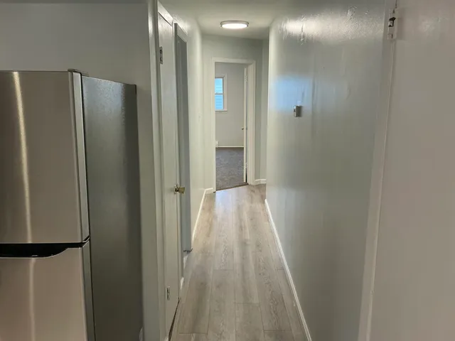 a view of a hallway with wooden floor