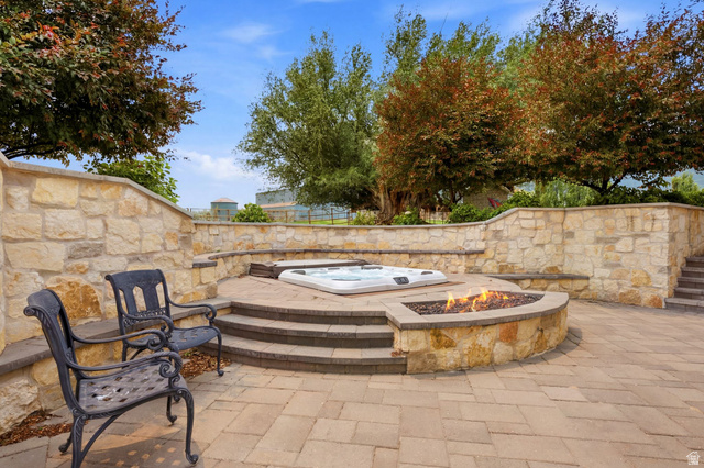 71 Farm Road Midway, UT 84049 - Photo 41 of 92 Expansive outdoor entertaining area featuring a built-in hot tub, a fire pit, and stone retaining walls