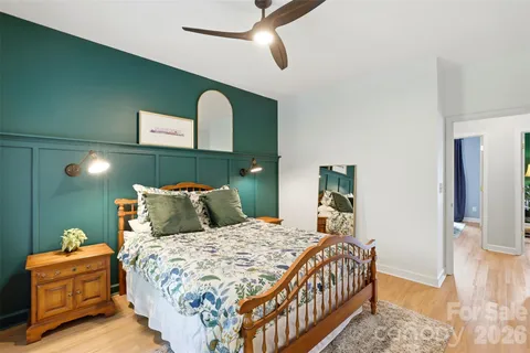 a bedroom with a large bed and a chandelier