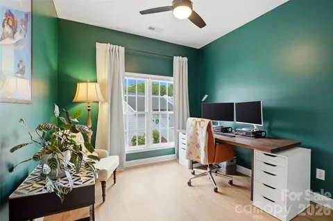 a view of a workspace with furniture and a window