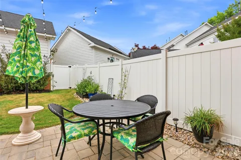 a view of a chairs and table in back yard of a house