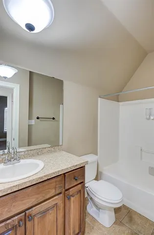 a bathroom with a granite countertop sink a toilet and a bathtub