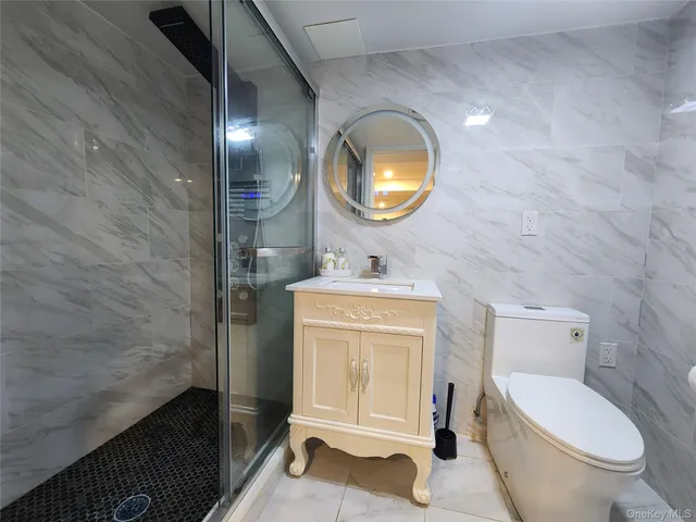 a bathroom with a toilet a sink a mirror and a bathtub