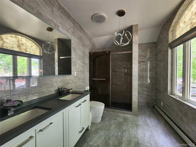 a bathroom with a sink a toilet a mirror and window