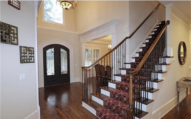 a kitchen with stainless steel appliances kitchen island granite countertop a stove top oven a sink dishwasher a dining table and chairs with wooden floor