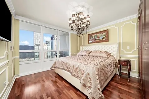 a spacious bedroom with a large bed and a chandelier