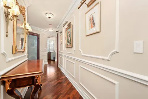 a view of a hallway with wooden floor and staircase