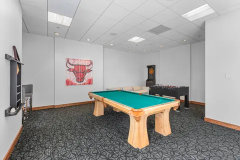 a room with pool table and windows