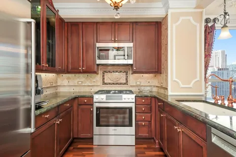 a kitchen with stainless steel appliances granite countertop a sink stove and refrigerator
