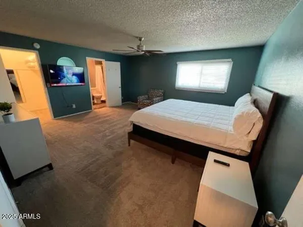 a bedroom with a bed chandelier and a window