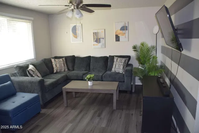 a living room with furniture and a wooden floor