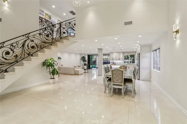 a large white kitchen with kitchen island a sink a center island stainless steel appliances and a cabinets