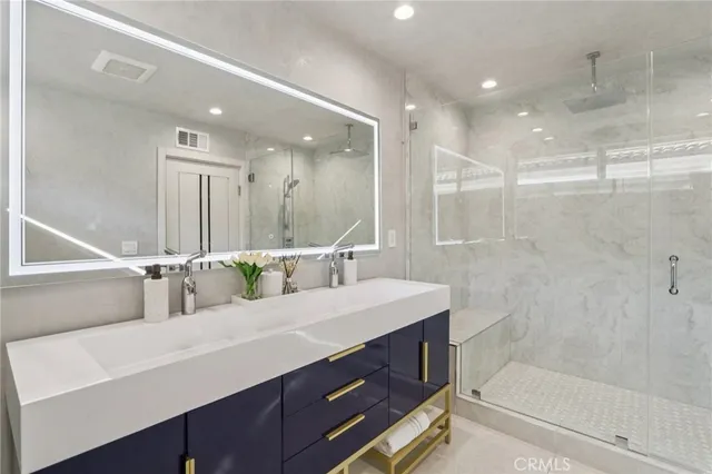 a bathroom with a shower sink vanity and mirror