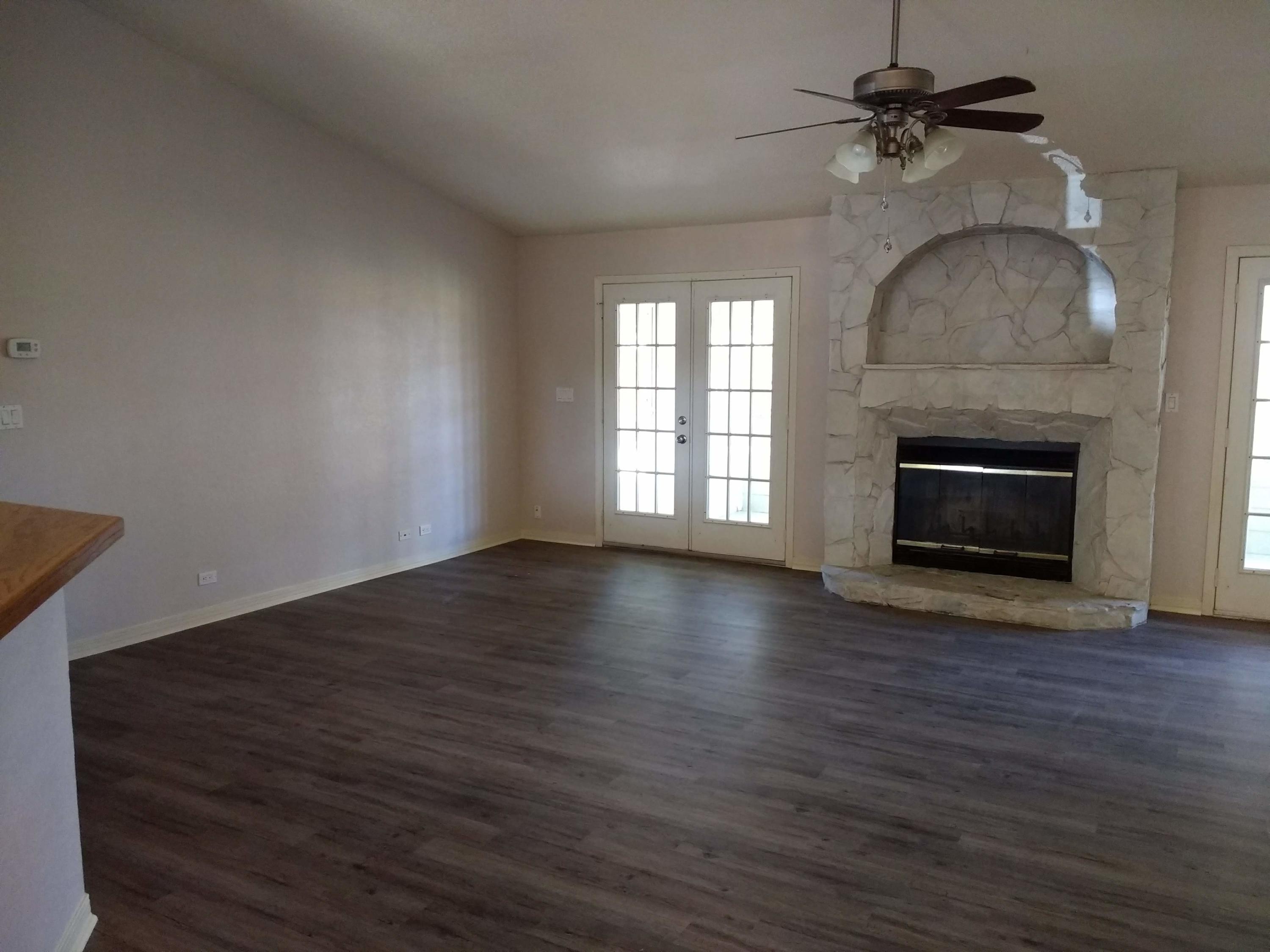 801 Cloverview Drive Crestview, FL 32536 - Photo 2 of 28 an empty room with wooden floor fireplace and windows