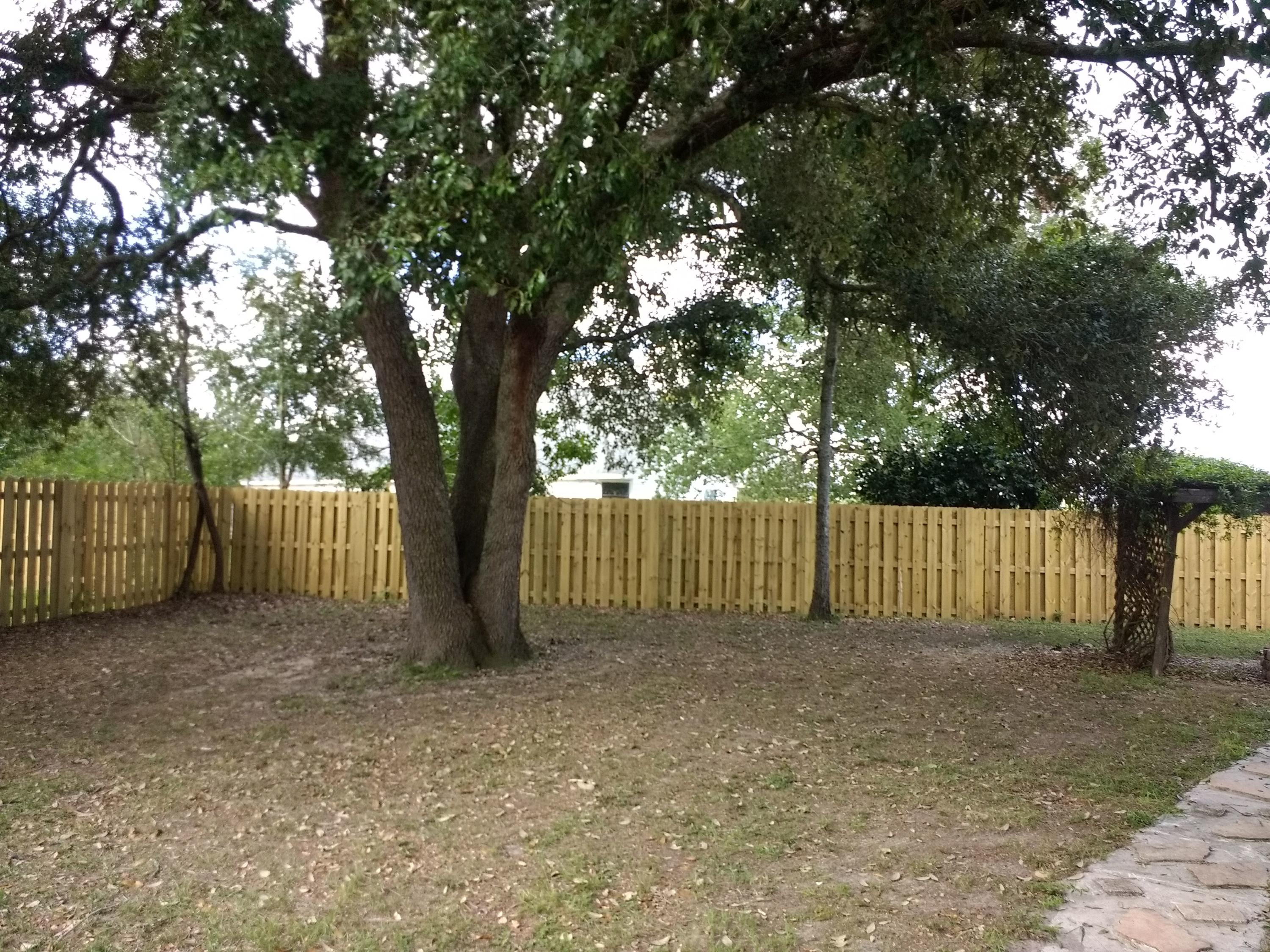 801 Cloverview Drive Crestview, FL 32536 - Photo 24 of 28 a view of backyard with large trees and wooden fence