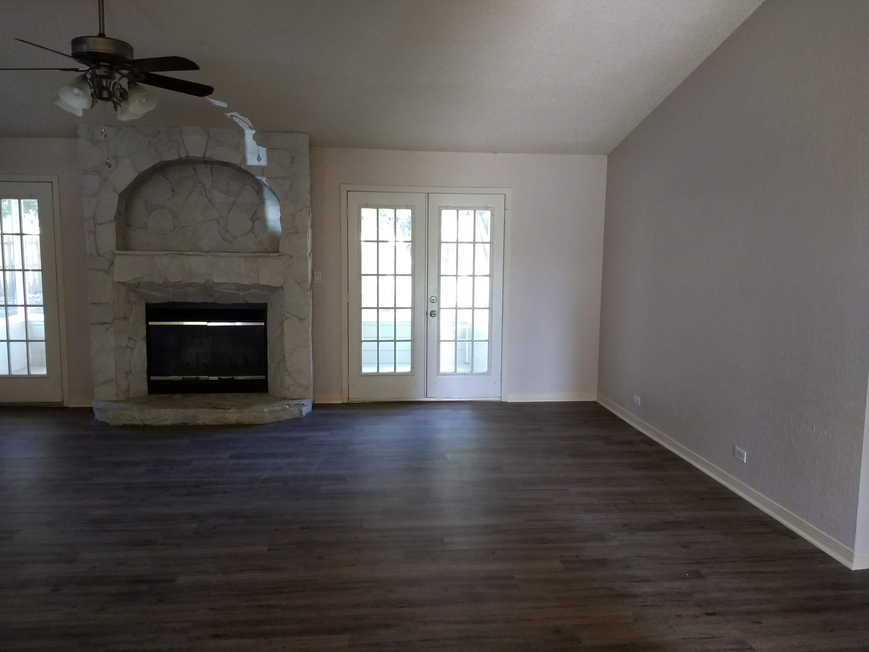 801 Cloverview Drive Crestview, FL 32536 - Photo 3 of 28 an empty room with wooden floor fireplace and windows