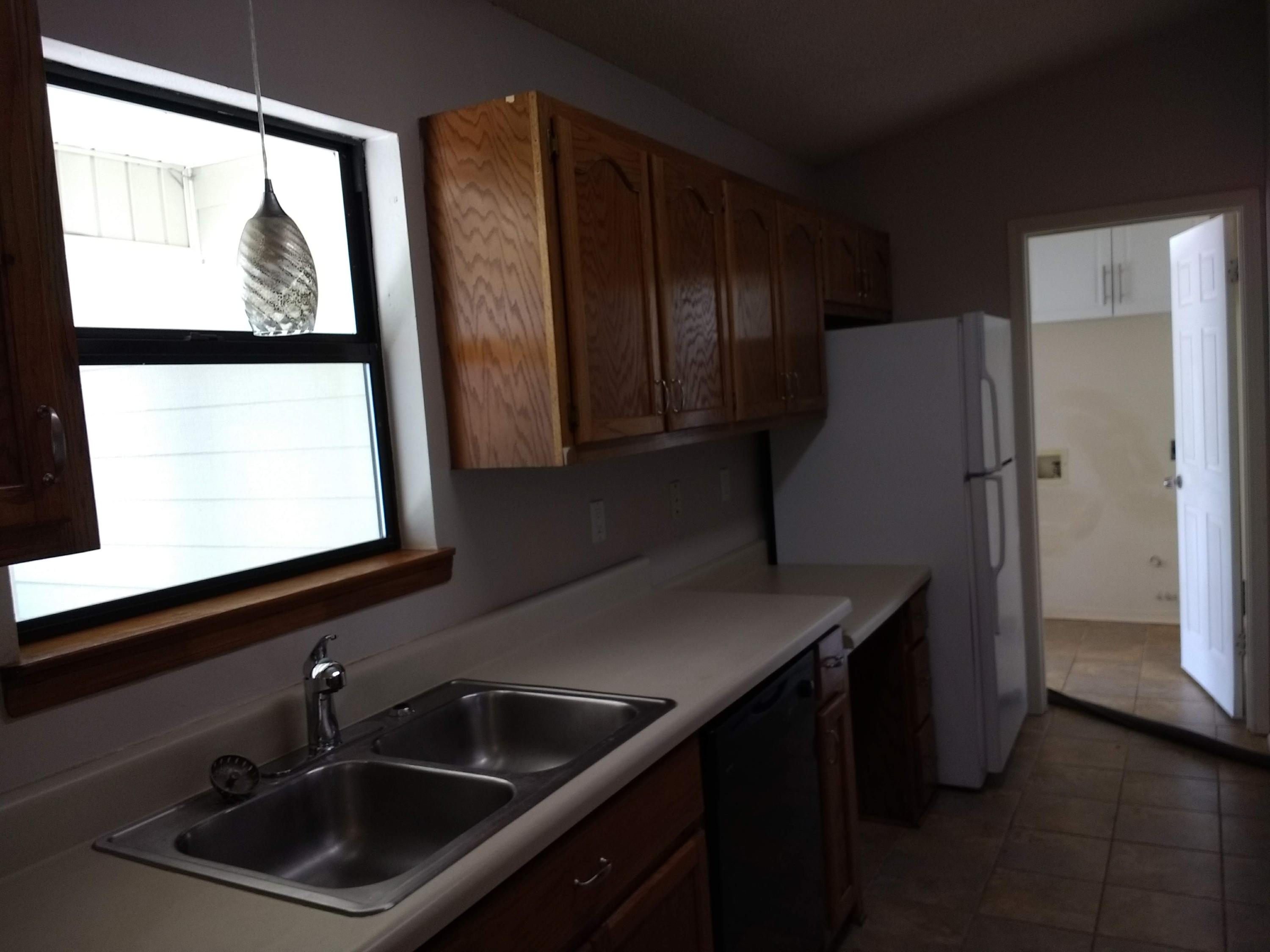 801 Cloverview Drive Crestview, FL 32536 - Photo 7 of 28 a kitchen with a sink and a refrigerator