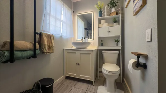 a bathroom with a toilet a sink and mirror