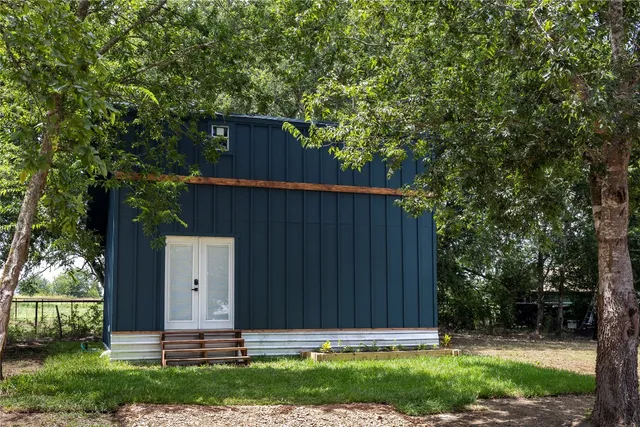 a view of house with backyard and a garden
