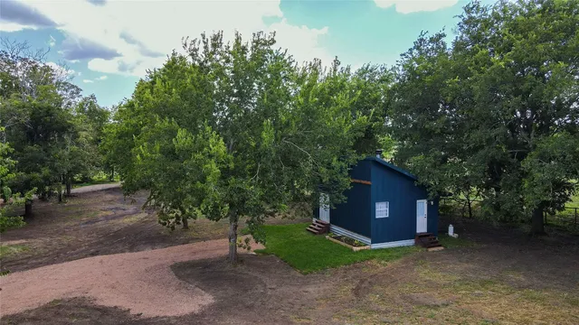 a view of a big yard with large trees