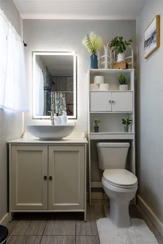 a bathroom with a toilet a sink and mirror