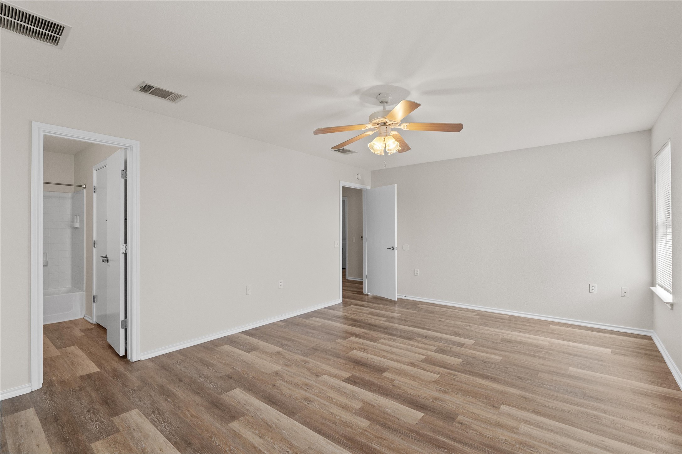 5825 Silver Screen Drive Austin, TX 78747 - Photo 16 of 40 A luminous living space features wide-plank wood flooring and a refreshing ceiling fan.