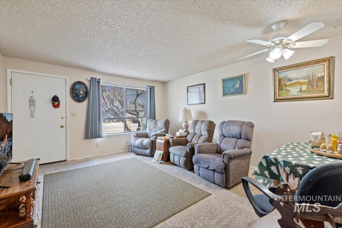 819 North Benjamin Lane Boise, ID 83704 - Photo 12 of 26 Living area featuring carpet floors, a textured ceiling, and a ceiling fan