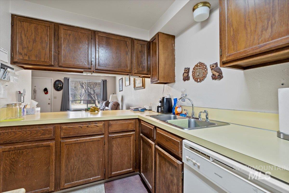 819 North Benjamin Lane Boise, ID 83704 - Photo 14 of 26 Kitchen with light countertops, dishwasher, and brown cabinetry