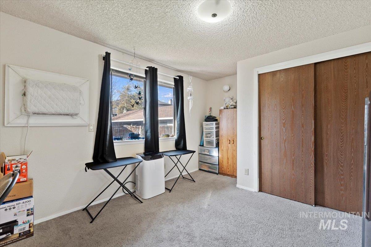 819 North Benjamin Lane Boise, ID 83704 - Photo 17 of 26 Unfurnished bedroom with a closet, light colored carpet, and a textured ceiling