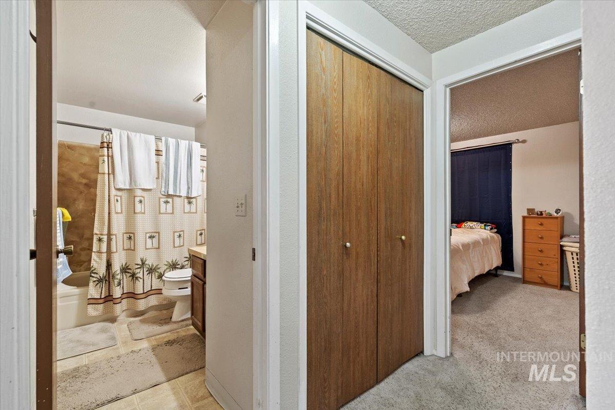 819 North Benjamin Lane Boise, ID 83704 - Photo 19 of 26 Hallway with a textured ceiling and light carpet