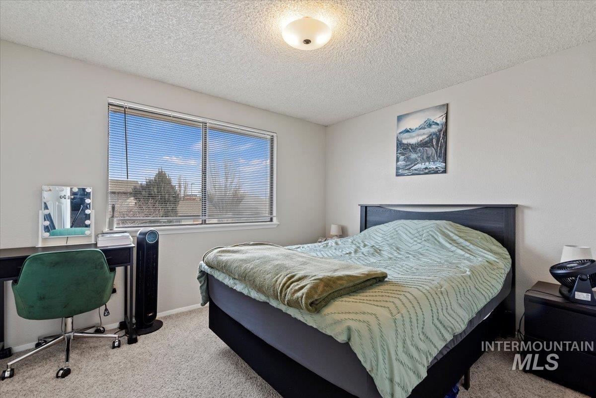 819 North Benjamin Lane Boise, ID 83704 - Photo 8 of 26 Bedroom featuring light carpet and a textured ceiling