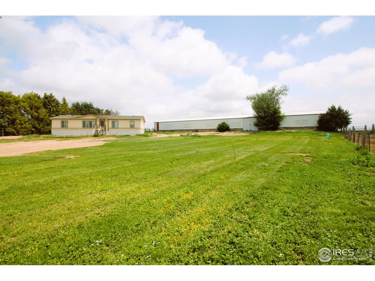 22354 County Road 41 Sterling, CO 80751 - Photo 1 of 40 a big yard with lots of green space and buildings in the background